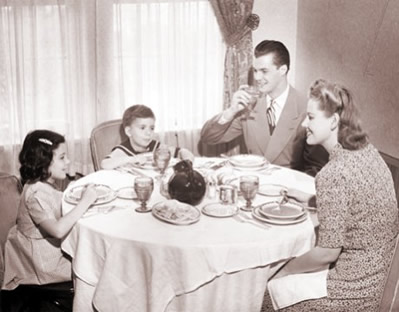 White middle class family of four at a dining room table around 1940