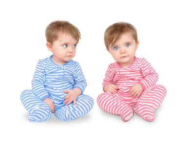 identical infants, one wearing blue and the other red.